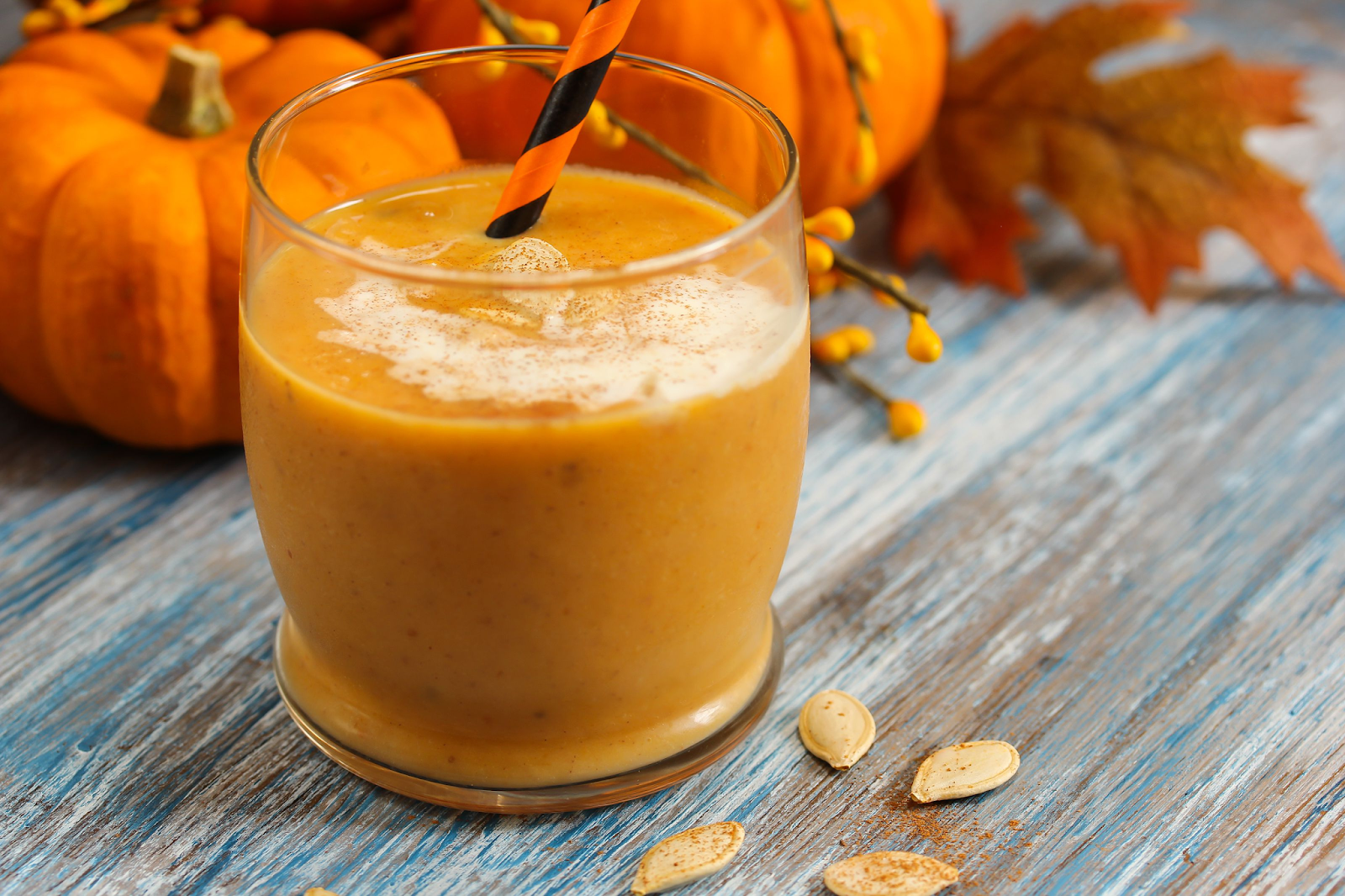 Pumpkin juice in a glass with a straw