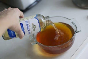 Pouring Kombucha into a glass jar