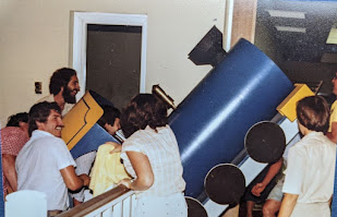 People lifting a large train piece