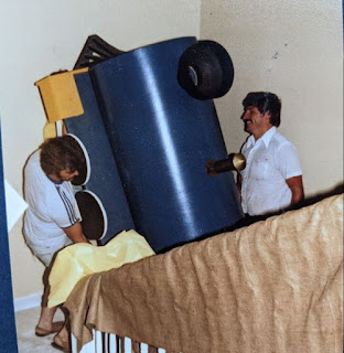 People lifting a large train piece