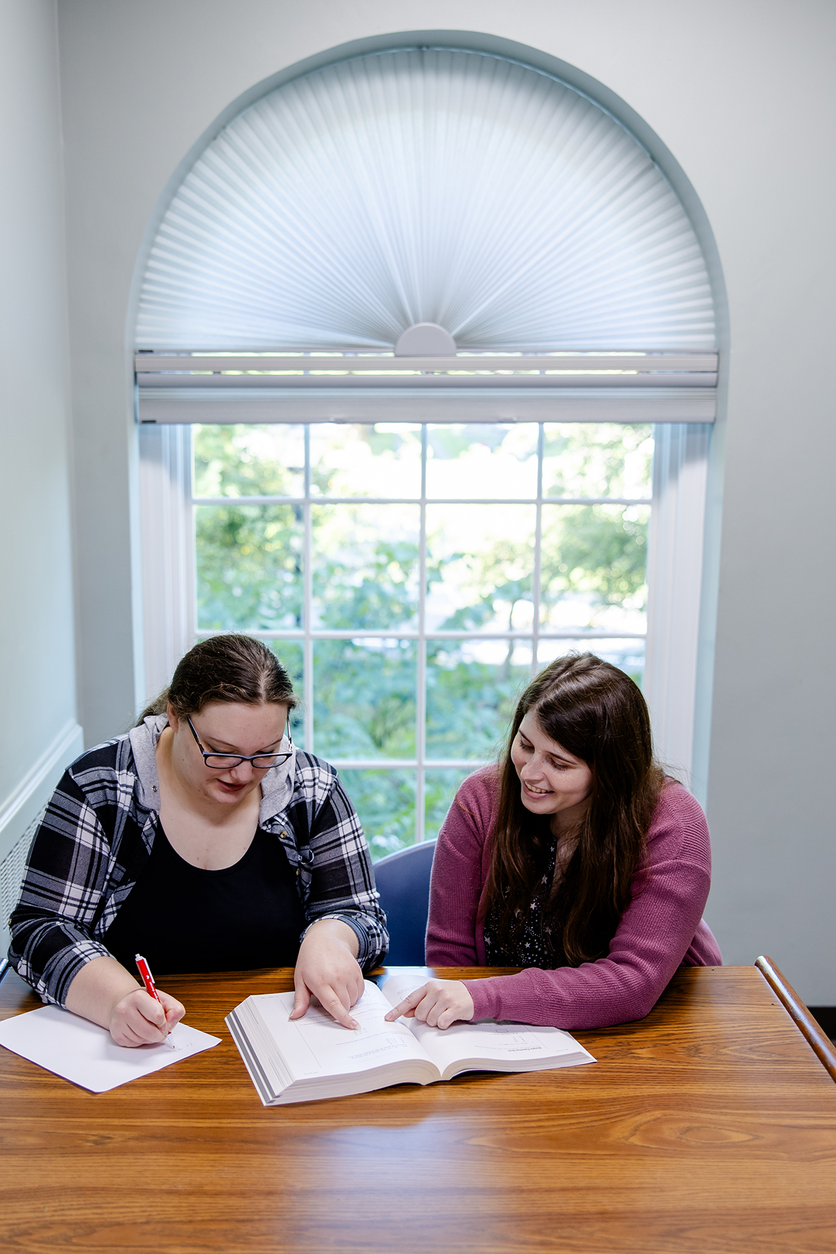 Two women using one of the study rooms to work on an assignment