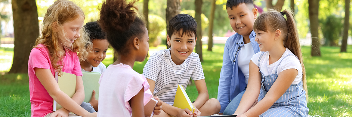 Group of children sitting in nature with books