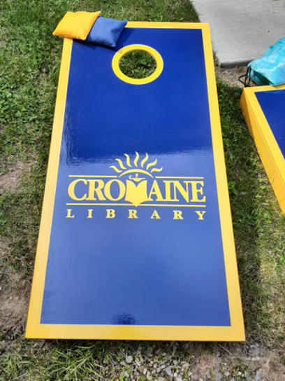 Corn hole game, decorated with the Cromaine logo. 