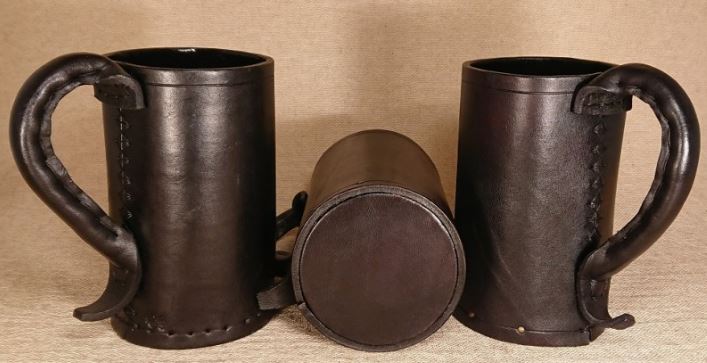 Three blackjack leather mugs, the middle one tipped to show the bottom of the mug. 