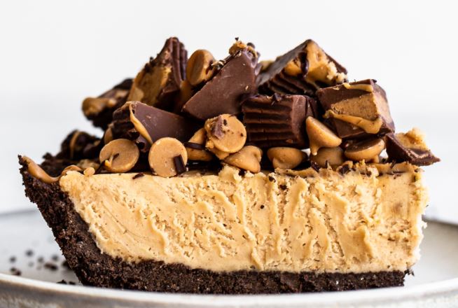 A slice of peanut butter pie, topped with peanut butter chocolate candy. 