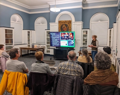 Michelle lecturing our Ale Together Now program in the Community Room, as her audience looks on.