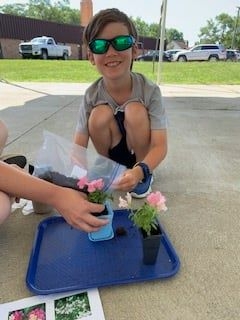 A young patron with small pots of flowers. 