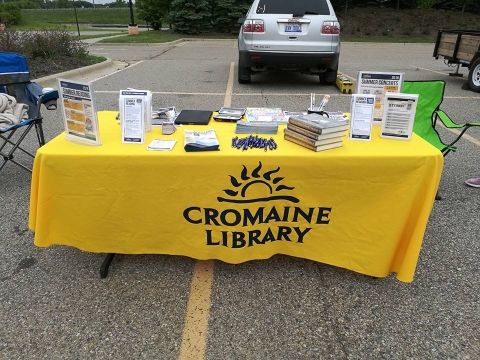 Table decorated with Cromaine tablecloth and giveaway items at the Farmer's Market. 