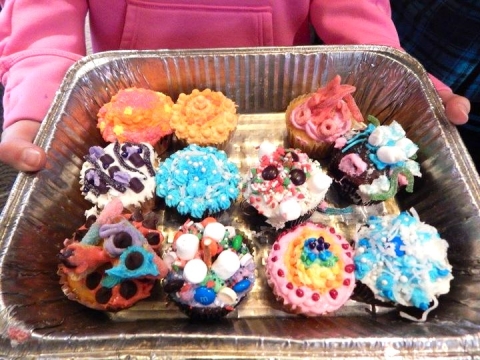 An assortment of decorated cupcakes on a platter. 