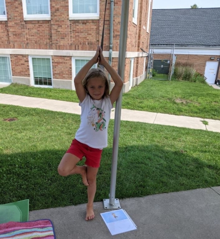 A young patron in a yoga pose in the South Lawn. 