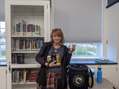 Michelle holding cans and bottles of craft beer. 