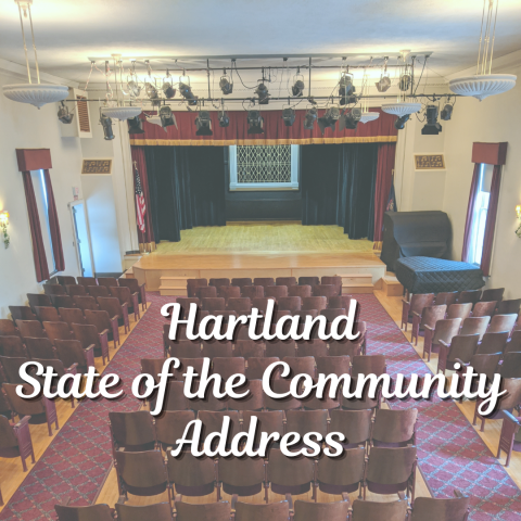 Looking towards the stage at the Hartland Music Hall with the lettering "Hartland State of the Community Address". 