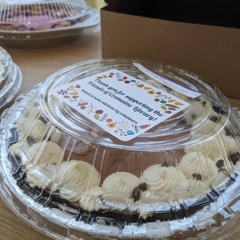 A pie in the Youth Program Room with a lid and sticker that reads "thank you for supporting the Friends of Cromaine Library!" 