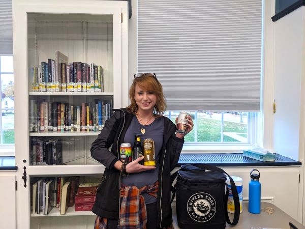 Presenter Michelle holding 4 different types of beer cans and bottles