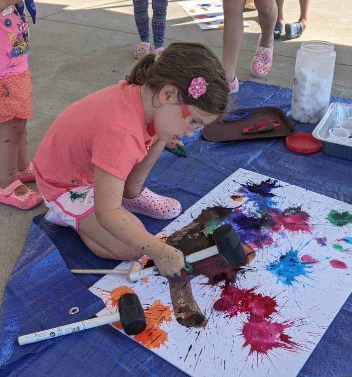 A young patron making a messy art masterpiece on the South Lawn. 