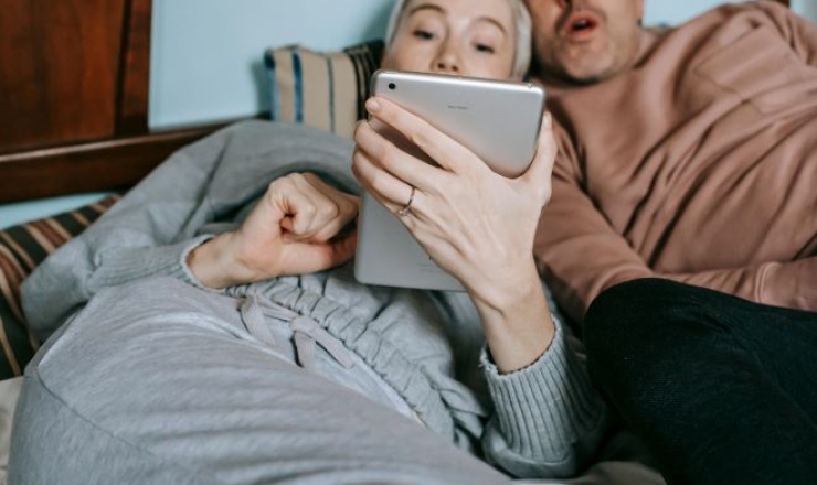 Image of two adults watching a movie on a tablet. Photo credit to Gary Barnes.